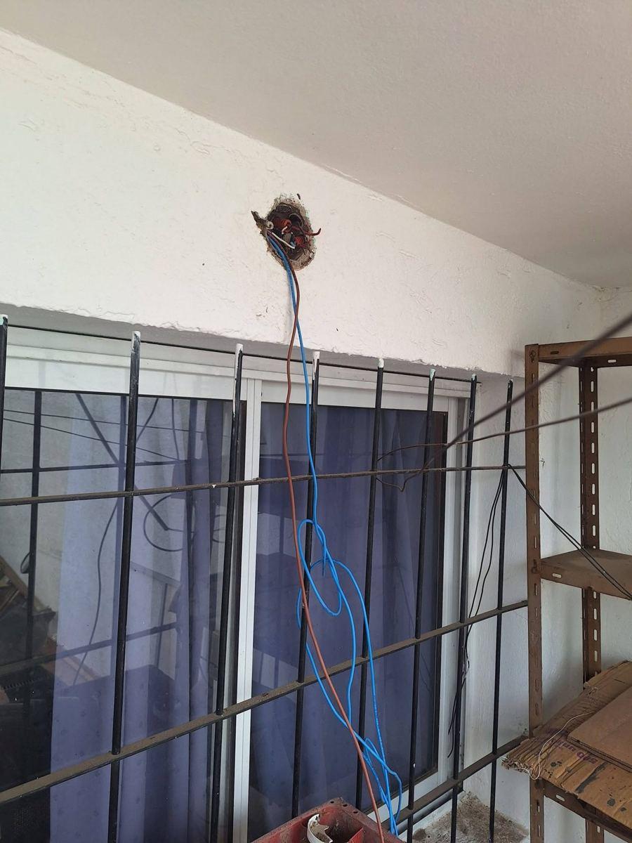 Cables nuevos saliendo de una caja de techo durante un cambio de cableado por cortocircuito en una galería