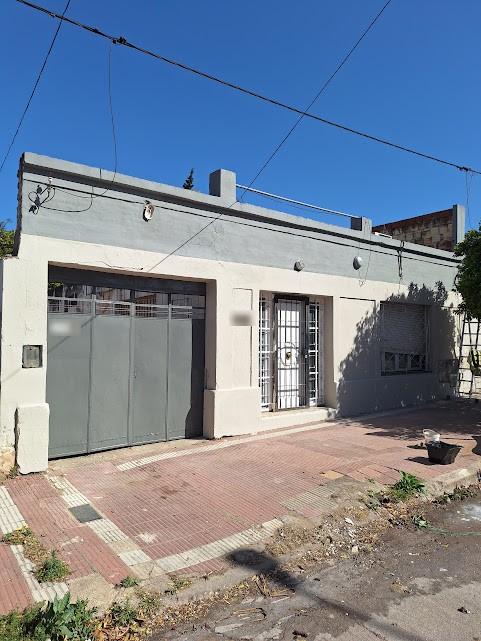El mismo frente de la vivienda recién pintado en tonos claros y gris